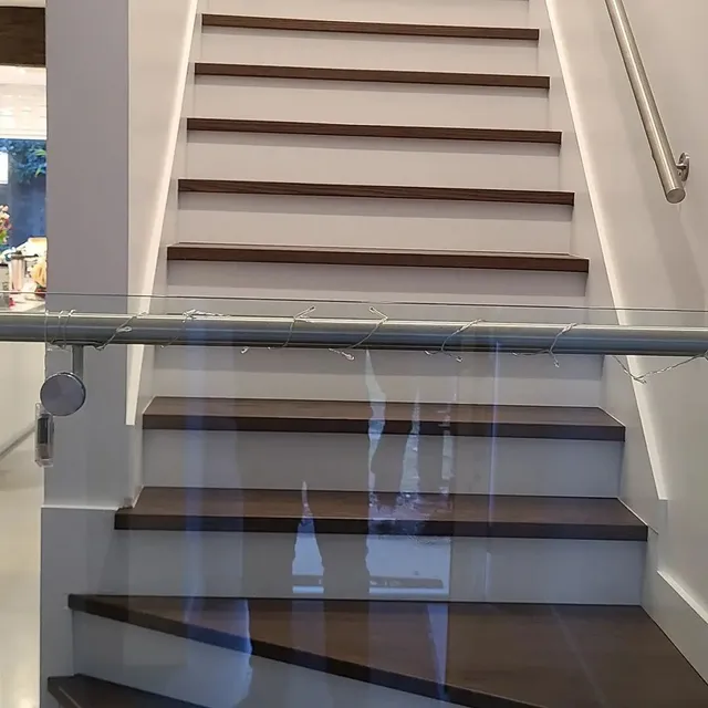 Finished custom stairs with skirt board and glass railing built by Valart Solutions in Port Coquitlam